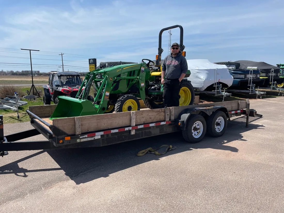 Customer loading a John Deere compact tractor bought at East Texas Equipment